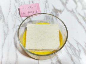 之后把夹好培根和芝士的吐司放在蛋液中，两面全部沾满蛋液。