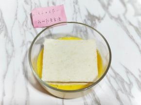 之后把夹好培根和芝士的吐司放在蛋液中，两面全部沾满蛋液。