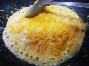 八成热时倒入咸蛋黄，炒至蛋黄起沫
