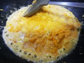 八成热时倒入咸蛋黄，炒至蛋黄起沫