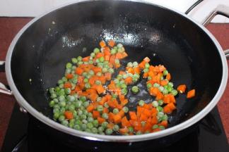 锅里有油，不需要加油，倒入甜豆、胡萝卜粒翻炒；