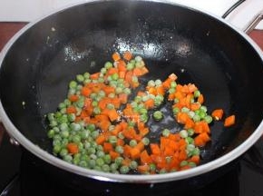 锅里有油，不需要加油，倒入甜豆、胡萝卜粒翻炒；
