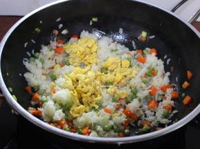 米饭与甜豆、胡萝炒均，能听到米饭巴拉巴拉响的时候，加入鸡蛋翻炒；