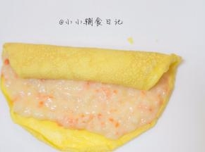 将蛋皮摊开均匀的抹上一层虾泥，靠近身体的地方留出一点不要抹，因为卷起来的时候虾泥会自动带蛋皮边缘来