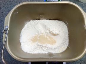 先放液体，再放面粉，糖和盐分别放在面包机桶对角，面粉上挖坑埋入酵母，启动程序揉面，揉至初步扩展，放入软化的黄油，继续揉至完全扩展状态，然后发酵。