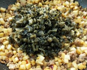 倒入焙干的腌菜。