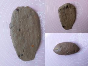 这是整理成长条橄榄形的手法，面团按扁后翻面，用擀面杖擀成牛舌状，底部压薄，自上而下卷起，捏紧收口处，朝下放置