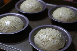 发酵好的面包表面刷上一层牛奶，撒上少许白芝麻。