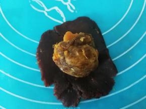 豆沙馅压扁，上面放一个蛋黄馅