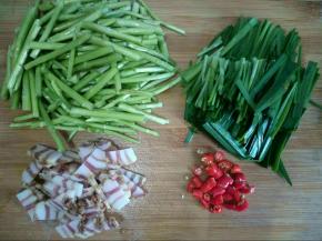 将藜蒿摘断、韭菜切段、小米椒切小段、腊肉切薄片。