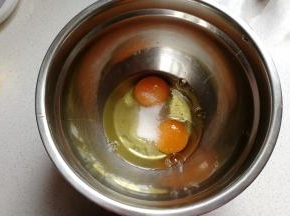 鸡蛋两个打入无油无水的干净盆中，先加入一半的白糖，用打蛋器打发至粗泡状态