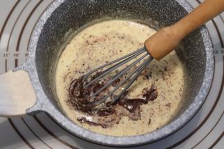 晃动淡奶油，使淡奶油全部盖住巧克力币，静置5分钟，画圆圈方式搅拌