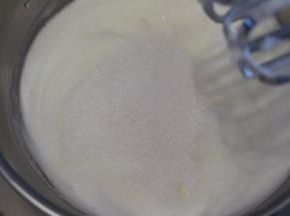 蛋白倒入无水无油的盆内，高速打发至成细腻的慕斯状，一次性加入剩余的细砂糖