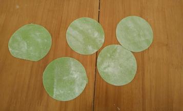 用压面机压出薄片，再用饺子模具压出圆形饺子皮。