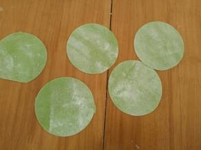 用压面机压出薄片，再用饺子模具压出圆形饺子皮。