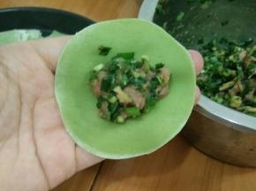 取一张饺子皮，放适量馅。