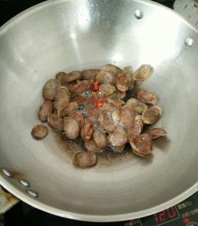小火慢煎至腊肠变透明，下辣椒段。