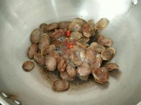 小火慢煎至腊肠变透明，下辣椒段。