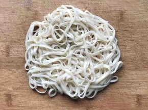 把沥干水分的面条放在砧板上，如图这样叠一起，等待面条变干