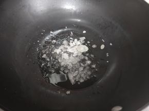 锅中加入适量油，加入冰糖，小火将冰糖融化。