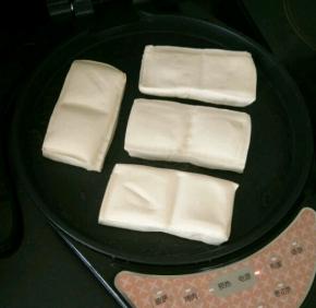 煎烤机刷一层薄油，放入豆腐，撒点盐。