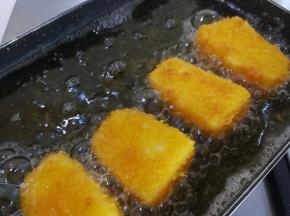 锅里放油，烧至七分热，中小火放入奶糕炸，一面金黄色后换一面，炸至两面金黄
