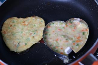 7、不粘锅放入少许油，烧热。用勺子舀入两勺糊糊，压平，两面摊至金黄即可。我为了工整用了煎蛋模具，不用也可以。