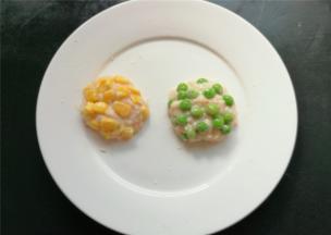 挖一勺磷虾肉泥，分别放上玉米，青豆，团成圆形