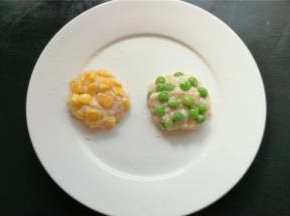 挖一勺磷虾肉泥，分别放上玉米，青豆，团成圆形