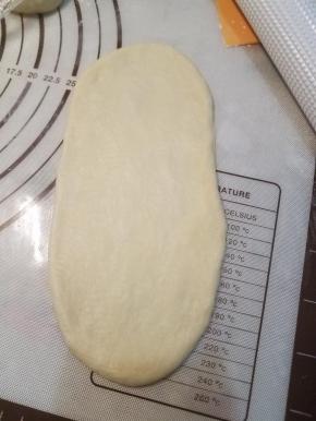 取一小块面团，擀成圆形，翻面。