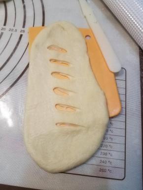 用锋利的小刀在面团的中间划开几道裂口。