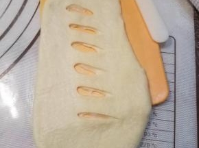 用锋利的小刀在面团的中间划开几道裂口。