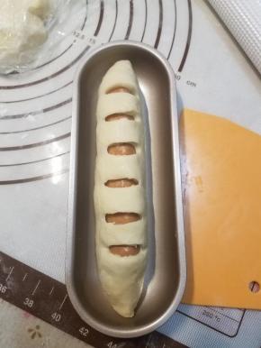 将脆肠放在中间，收口捏紧，装入模具。