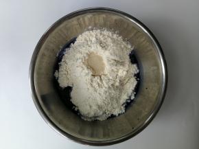 蝶豆花水中加入白砂糖和高筋面粉，然后加入干酵母，用筷子搅拌成絮状后用手揉匀