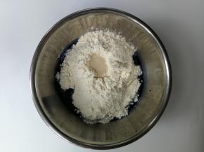 蝶豆花水中加入白砂糖和高筋面粉，然后加入干酵母，用筷子搅拌成絮状后用手揉匀