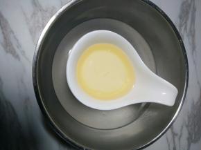 2、牛奶和玉米油倒入容器内，隔热水加热保温。