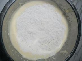 4、在蛋糊里加入过筛的低筋面粉和泡打粉，采用翻拌的手法混合，手法要清，动作要快，不超过20下翻拌均匀即可。