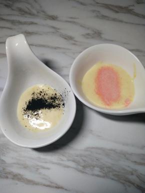 6、取少量的面糊放入2个容器里，分别加入少量的竹炭粉和草莓粉拌匀。