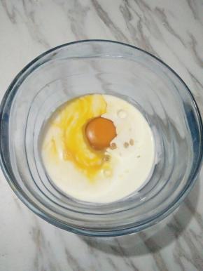 现在来做椰蓉馅。鸡蛋加淡奶油（加融化的黄油也可以，量要减少10克）混合均匀。