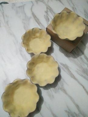 将冷藏好的面团取出，平均分成8份，喜欢塔皮厚一点的可以分成6份。取一塔皮，擀成圆形，放入模具里，底部压平，慢慢往上推，使之与模具贴合。