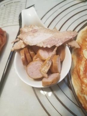 脆皮肠切片待用，培根切丝。