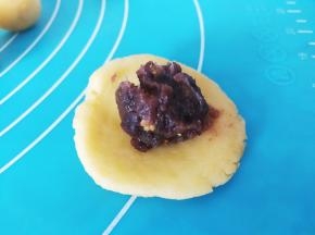 取一份面团压扁，挖一点豆沙馅放在皮上面（千万不要多哦），包裹起来搓圆