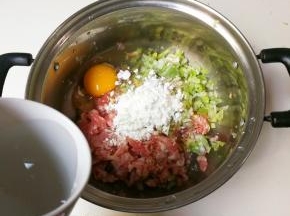 放入鸡蛋，玉米淀粉和适量清水顺时针搅拌至有粘性的肉馅