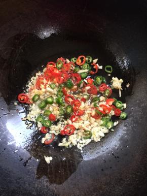 锅烧热倒入适量的油，放入蒜蓉姜丁，青红尖椒圈小火煸炒。