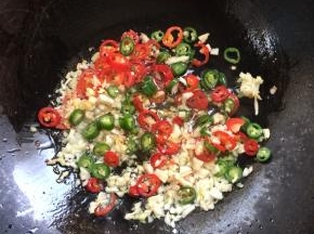 锅烧热倒入适量的油，放入蒜蓉姜丁，青红尖椒圈小火煸炒。