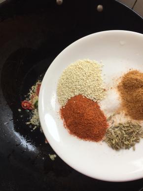放入辣椒粉，小茴香籽，孜然粉，盐和白芝麻小火煸炒出香味儿。