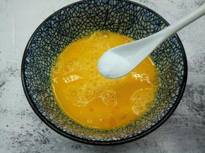 用筷子顺时针把鸡蛋液打散，加半勺盐