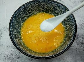用筷子顺时针把鸡蛋液打散，加半勺盐