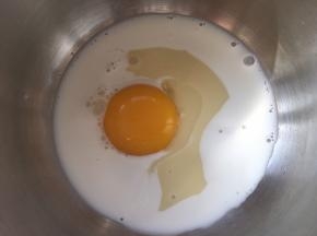 容器内加入牛奶、炼乳跟一颗蛋黄