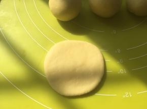 取一份面团，用擀面杖擀成圆片，风干的一面朝下，面皮被风干时，表面水份流失，这样擀出来的面团自带褶皱，很像金桔的表面